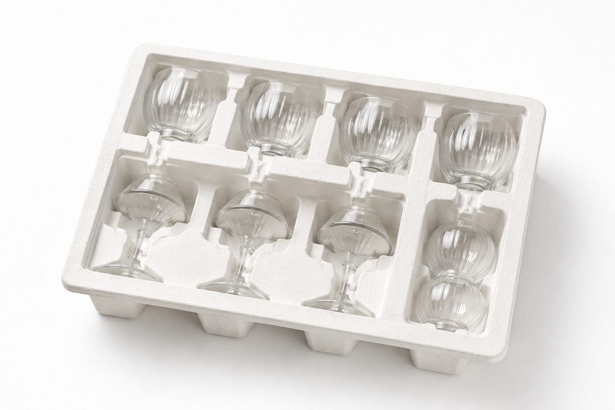 Custom white molded pulp packaging tray for fragile glassware, designed with individual cavities to securely hold wine glasses and glass cups, improving product protection, organization, and presentation during shipping and retail packaging.